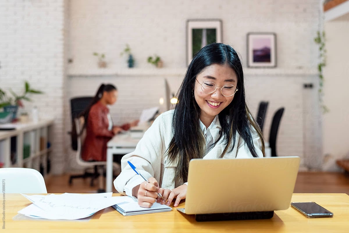 woman smiling down at her laptop
