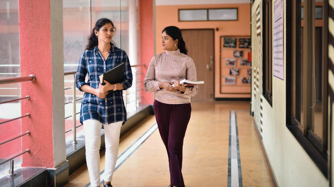 external-feedback-colleagues-walking-in-hallway-talking