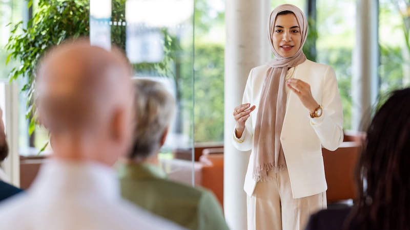 trait-theory-of-leadership-woman-presenting-at-team-meeting-as-leader