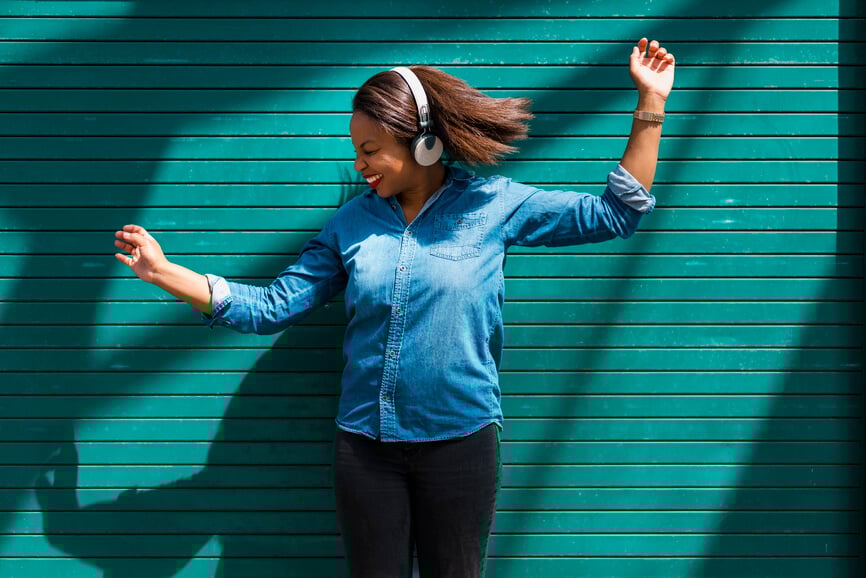 woman-dancing-and-smiling-listening-to-music-benefits-of-music